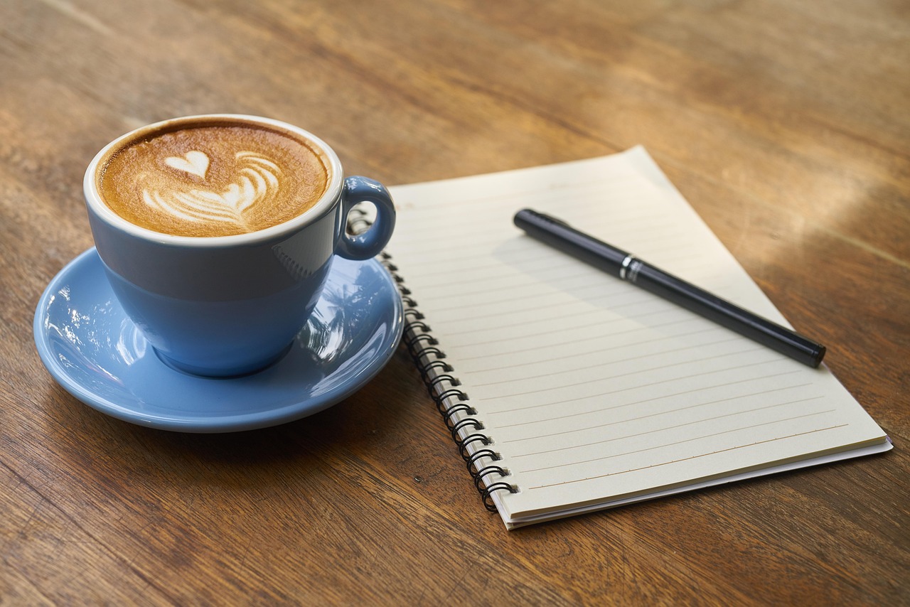 Notebook and coffee for organising a travel itinerary